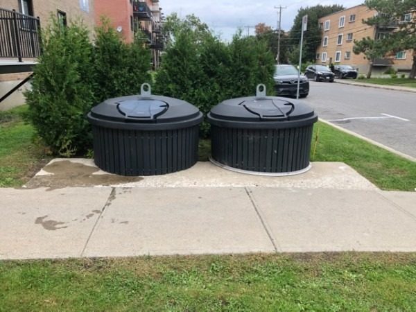 Conteneurs semi-enfouis entretenus devant un immeuble résidentiel